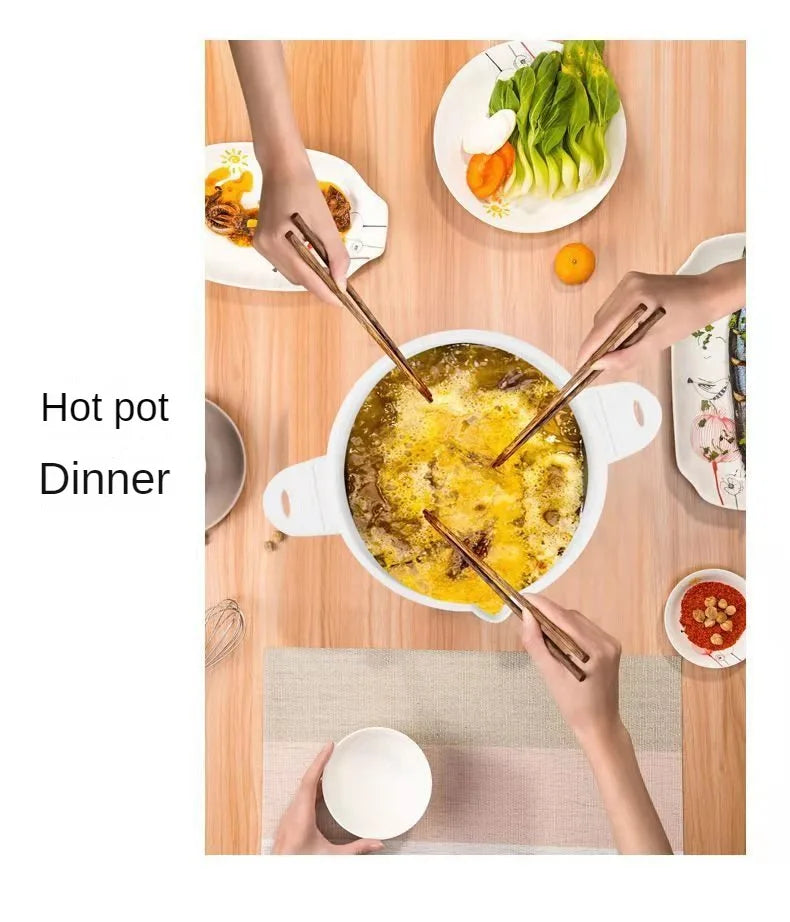 White foldable electric cooking pot with lid and side handles, shown with warm meal preparation