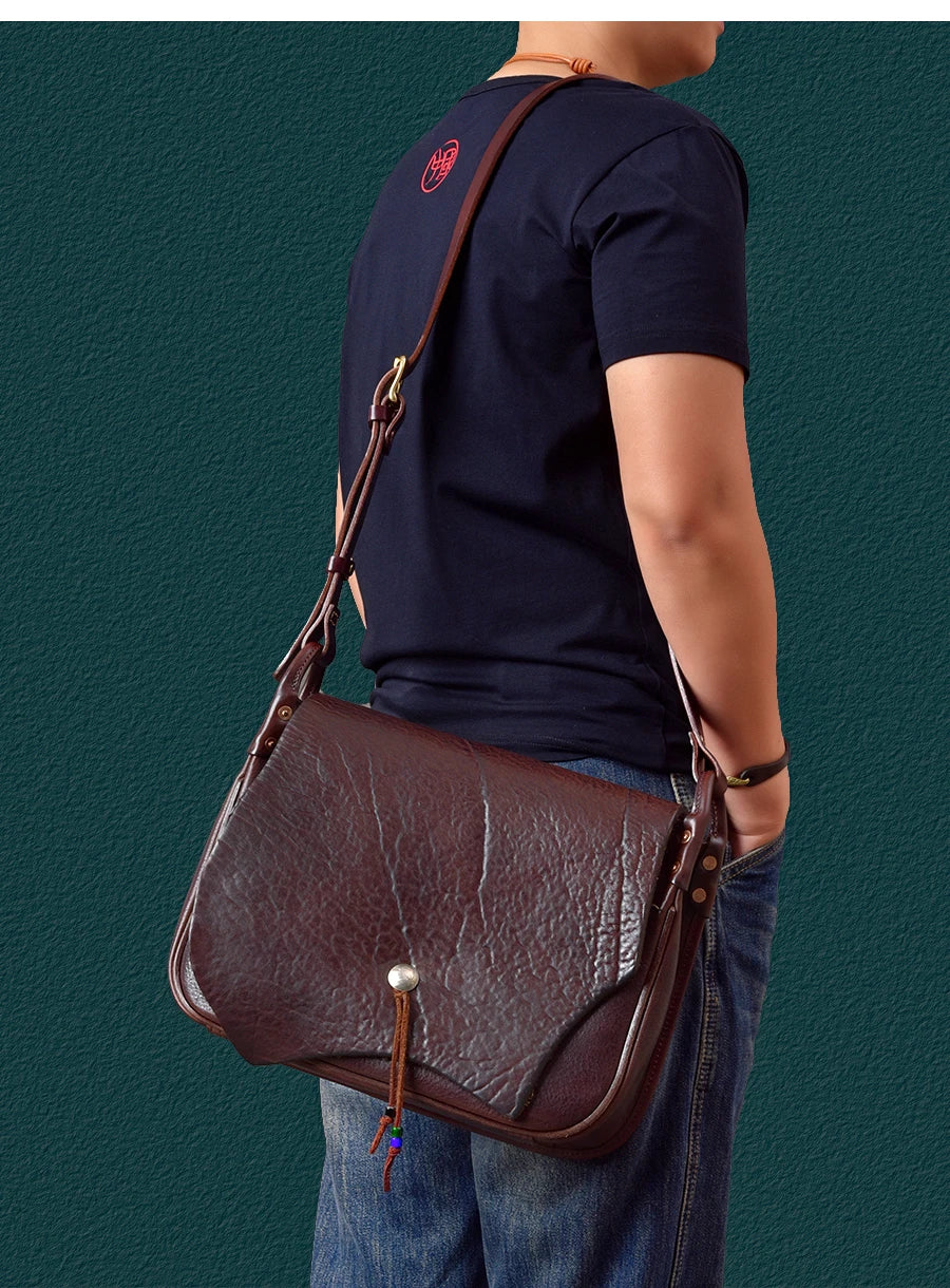 Vintage dark brown genuine cowhide messenger bag with textured leather, adjustable strap, and metal toggle closure.