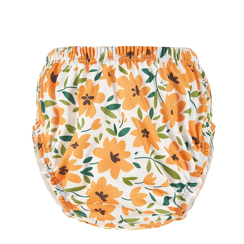 Baby care swim diaper with orange floral print and green leaves on white background, elastic waistband, reusable style.