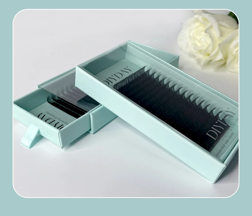 Two light blue slider boxes containing 16 rows of black individual mink eyelash extensions on a white background.