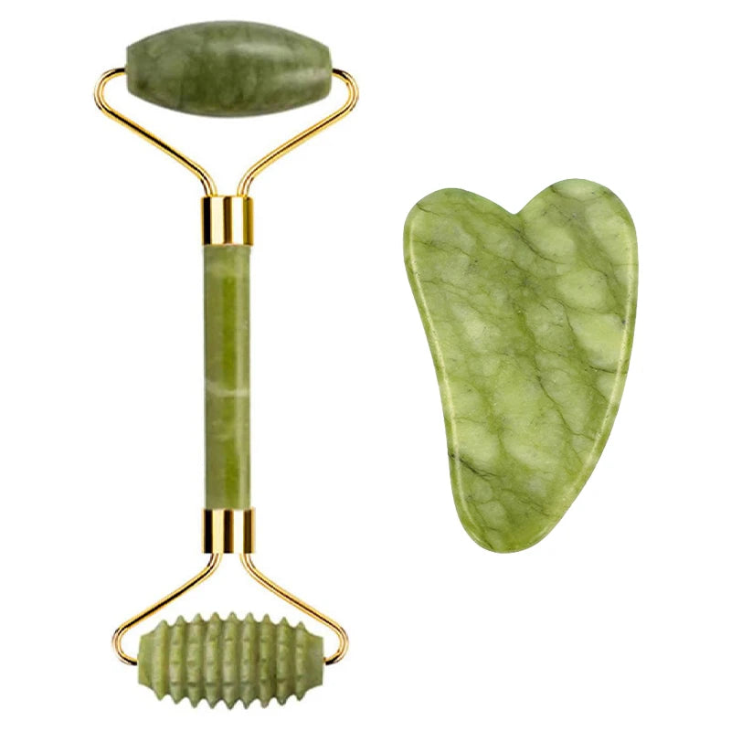 Green jade facial roller with smooth and textured ends, plus a heart-shaped gua sha stone, both with gold accents.