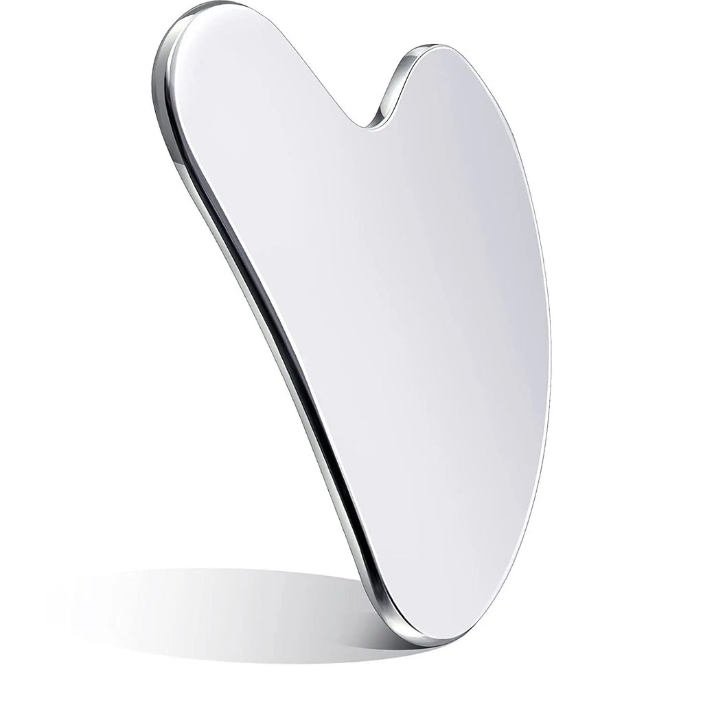 Heart-shaped, smooth, silver-metallic gua sha facial massage tool standing upright against a white background.