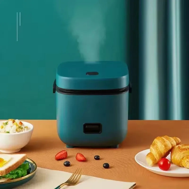 Mini electric rice cooker, teal countertop unit with closed lid and base handle