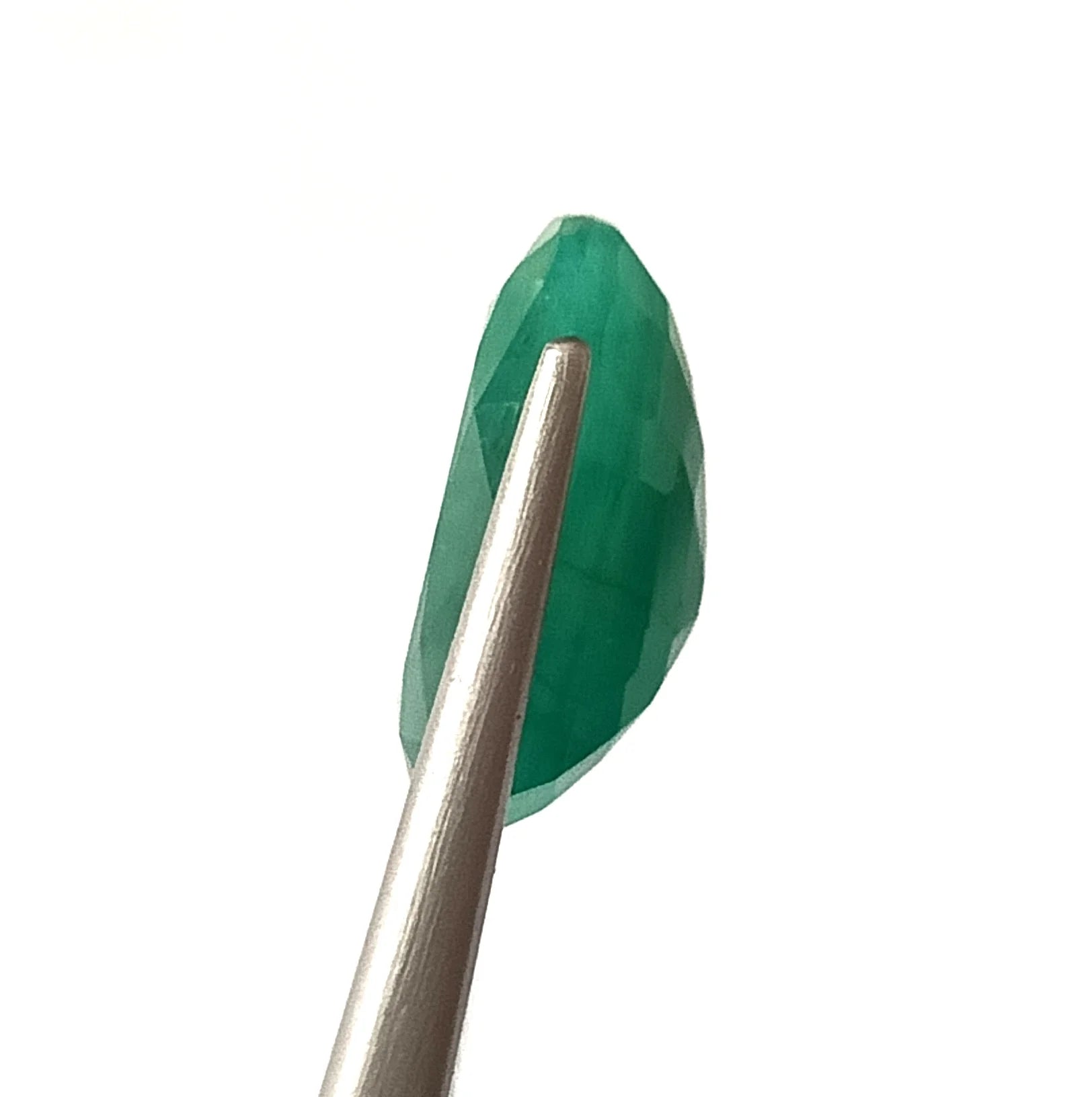 Oval green emerald gemstone, side profile view with faceted edges
