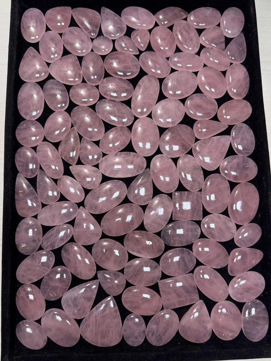 Assorted rose quartz cabochon stones in light pink, oval cabochons with smooth shine