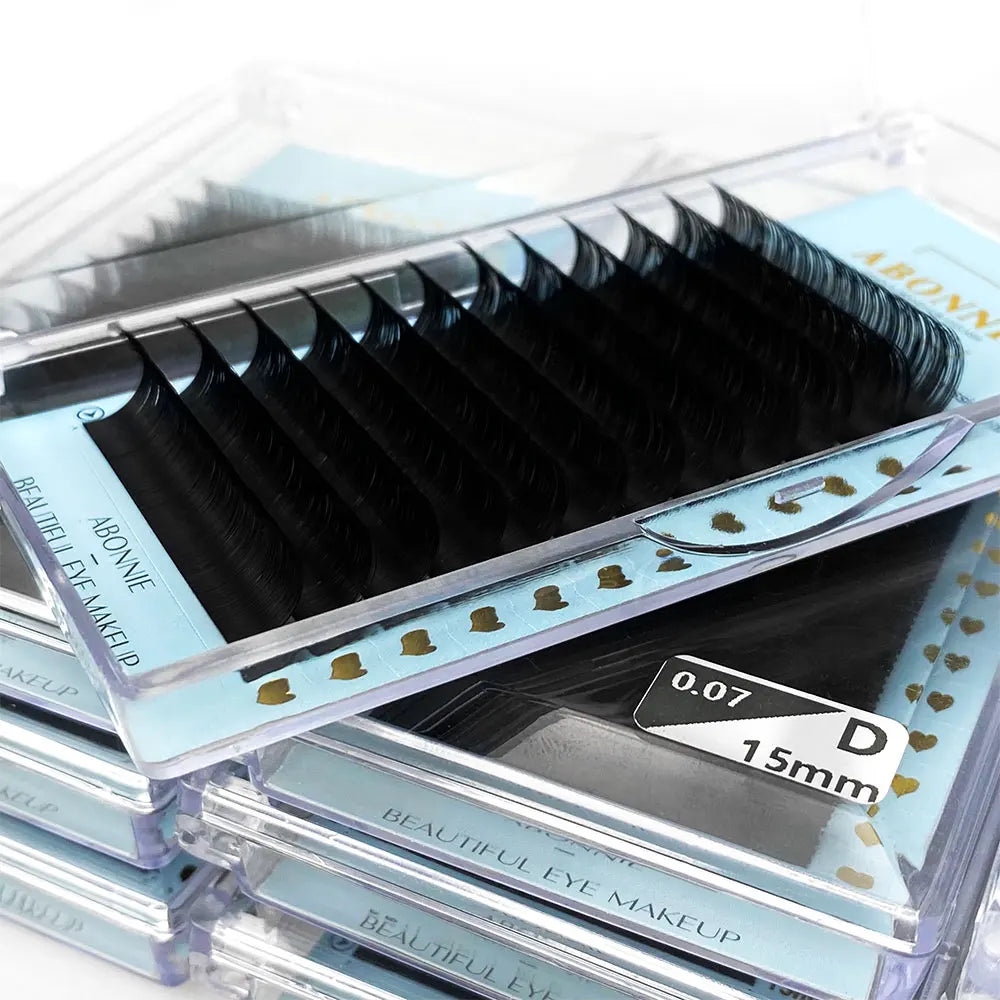 Stack of Abonnie ultra-matte black individual eyelash extension trays with a D-curl, 0.07 thickness, 15mm length.