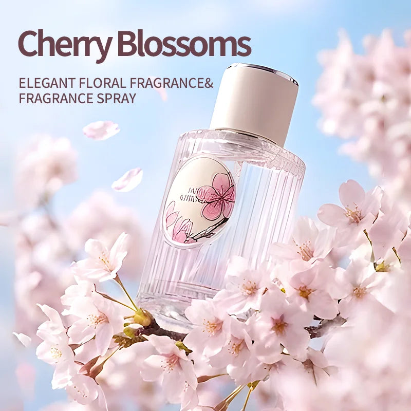 Clear glass perfume bottle with a white cap, featuring a floral Sakura label, surrounded by pink cherry blossoms.