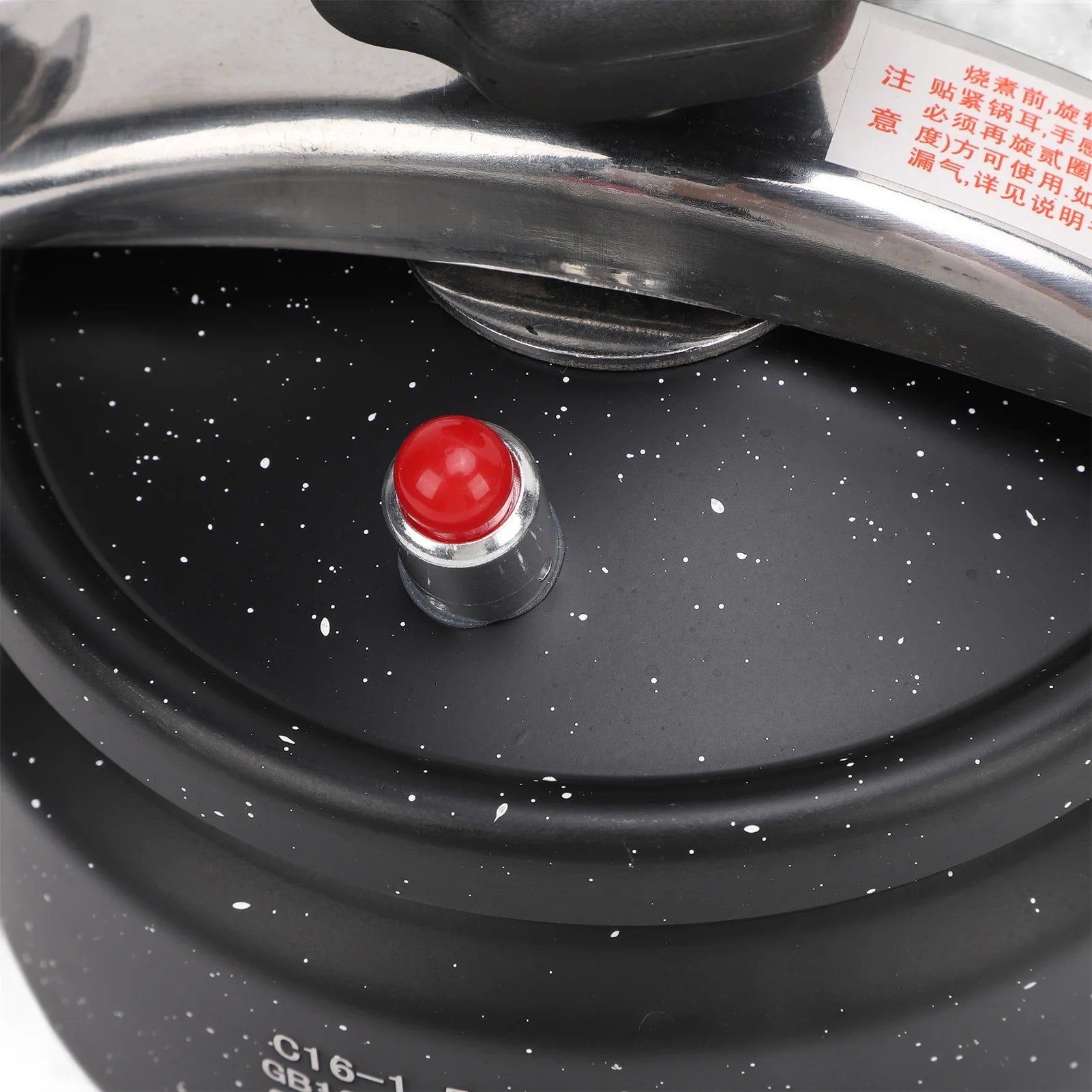 Black pressure canner lid with red safety indicator cap and pressure valve vent