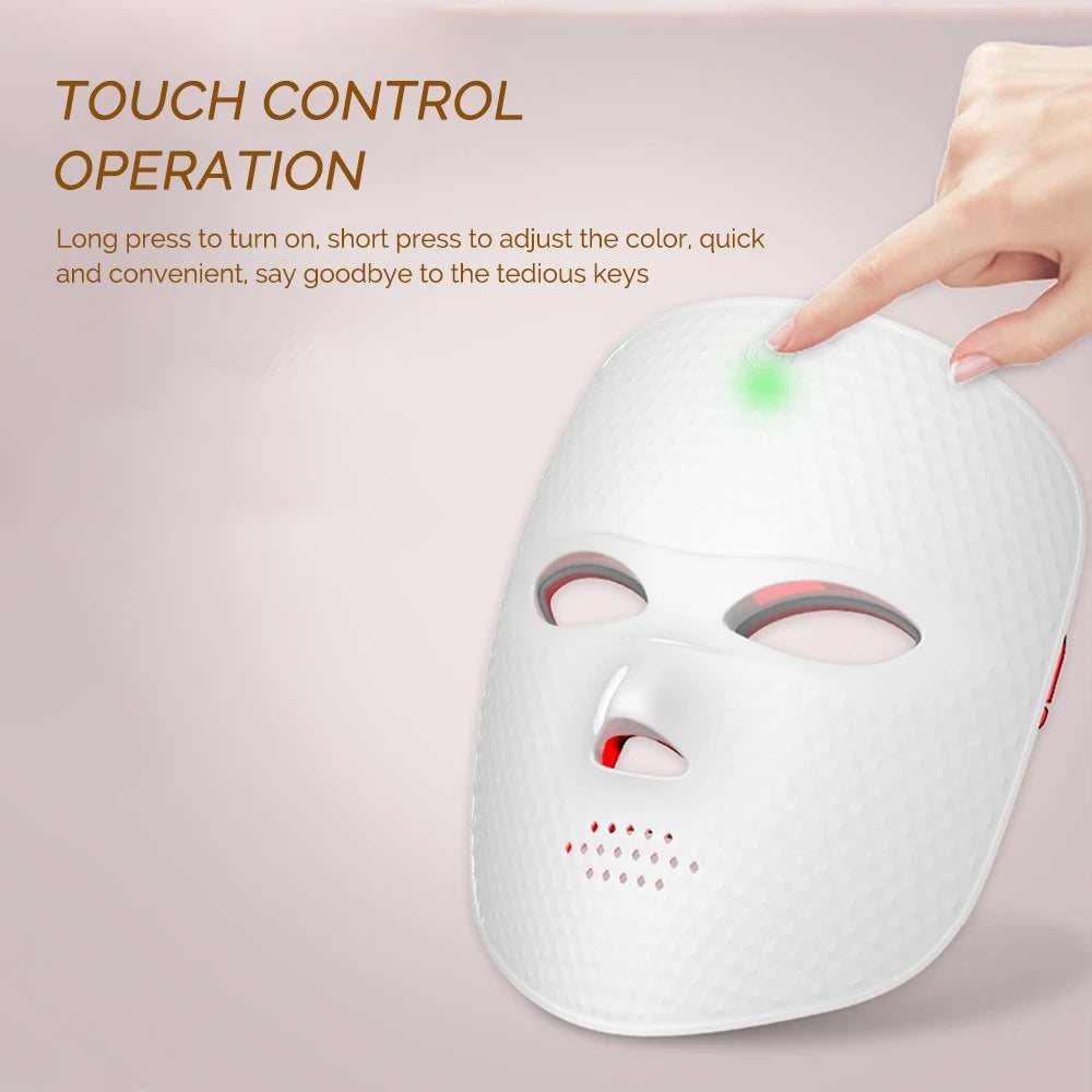 White, textured LED facial beauty mask with a touch-control sensor glowing green while being tapped by a finger.