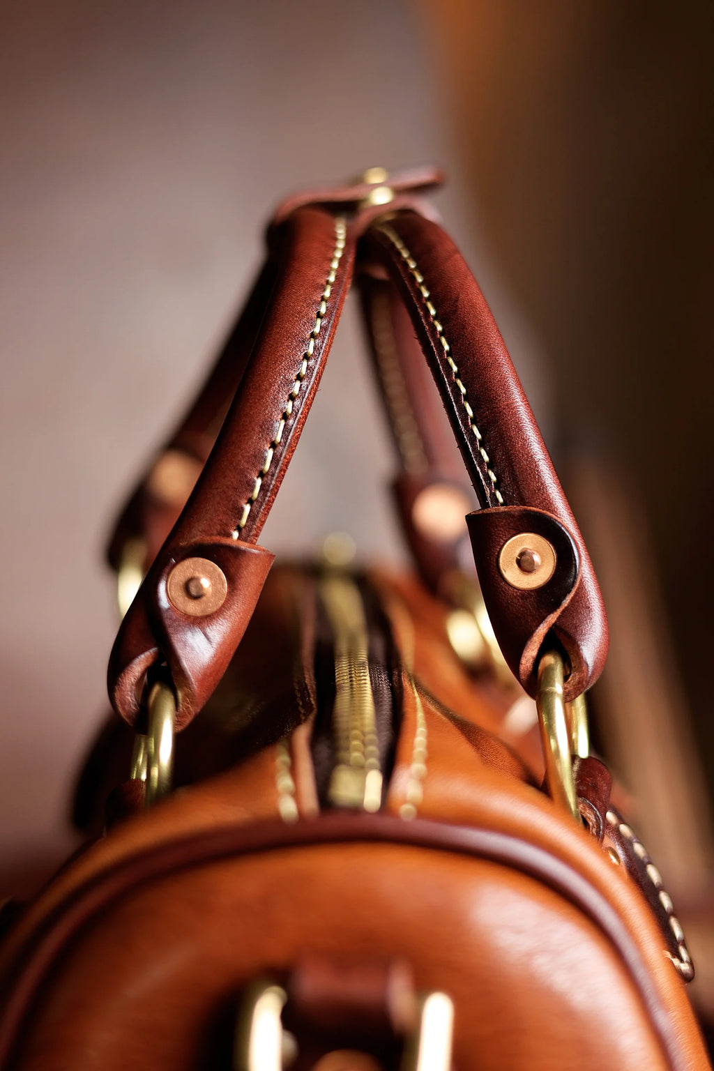 Vintage PNDME handmade brown cowhide leather handbag with brass hardware and reinforced stitched handles.