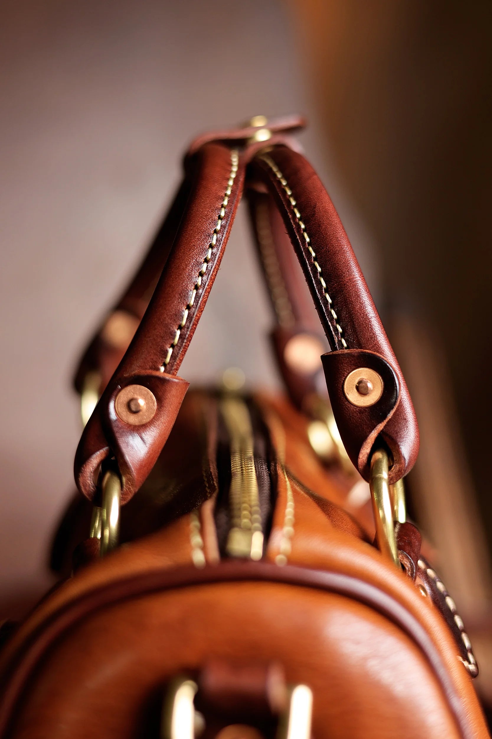 Vintage PNDME handmade brown cowhide leather handbag with brass hardware and reinforced stitched handles.