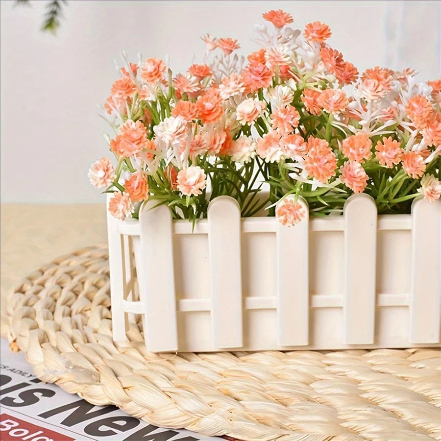White rectangular planter pot with fence design, filled with coral and white flower heads