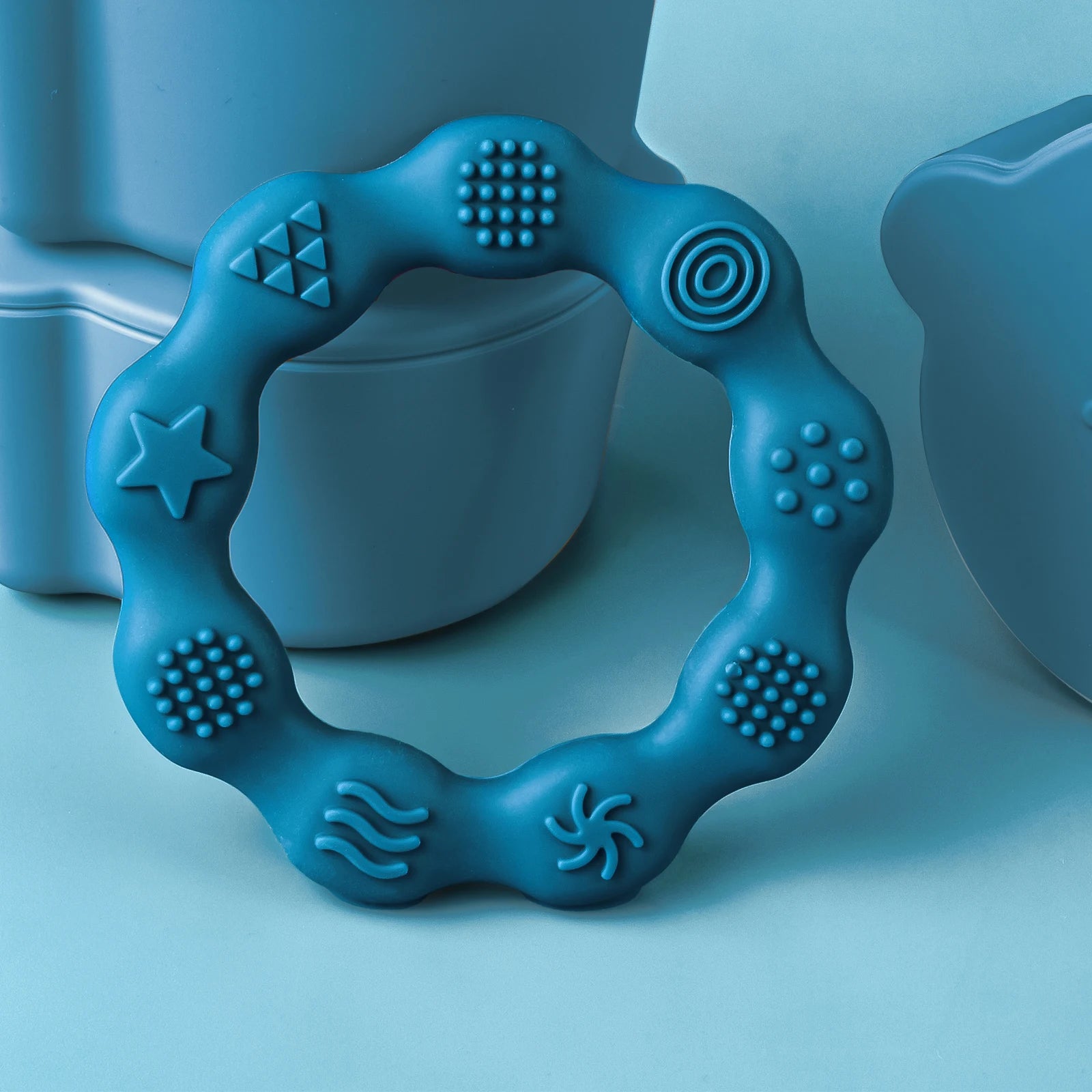 Blue silicone baby teething ring with sensory textures for soothing teething relief.
