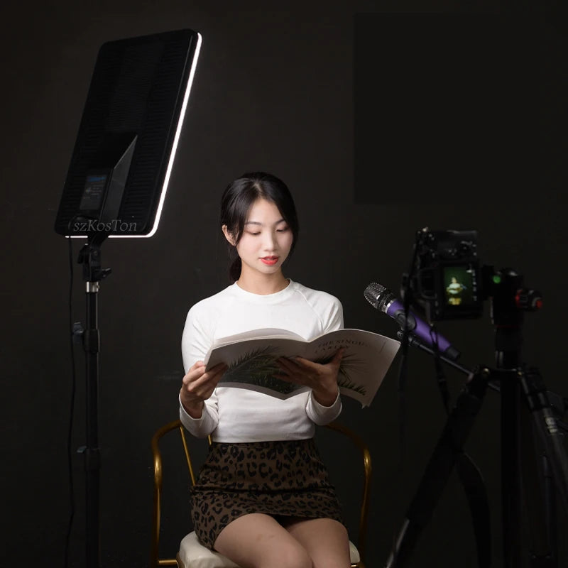 Rectangular black LED studio light panel on a tripod stand, used for professional lighting during recording.