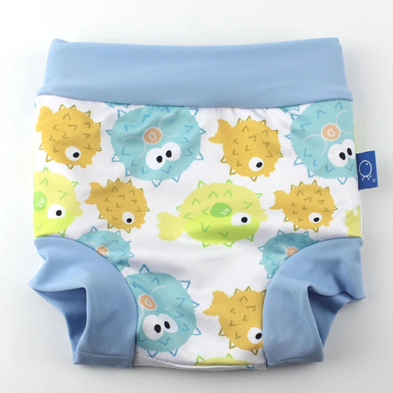 Reusable baby swim diaper with cute yellow and blue pufferfish print on white fabric.