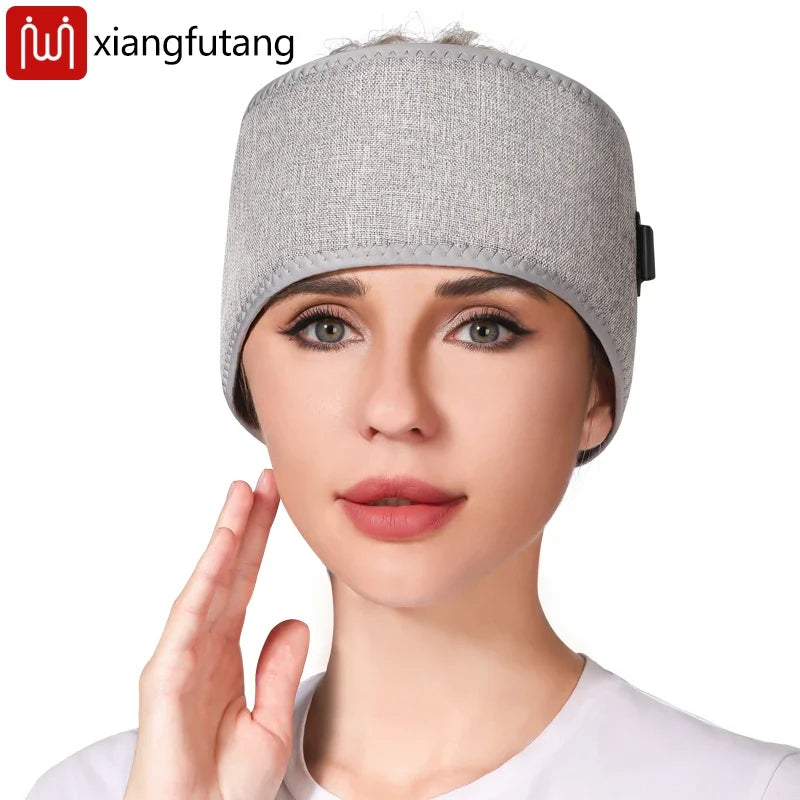 Woman wearing grey heated full-wrap headband massager for migraine relief, stress reduction, and red light therapy.