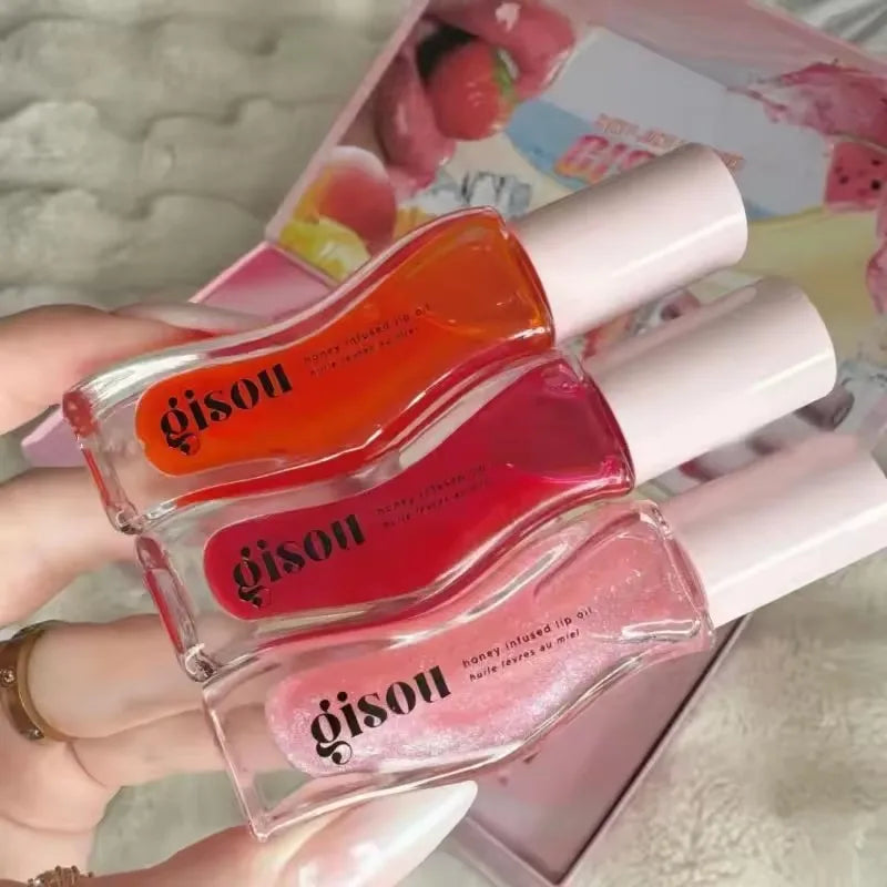 Gisou honey-infused moisturizing lip oil set in orange, red, and shimmering pink shades for glossy, smooth lips.