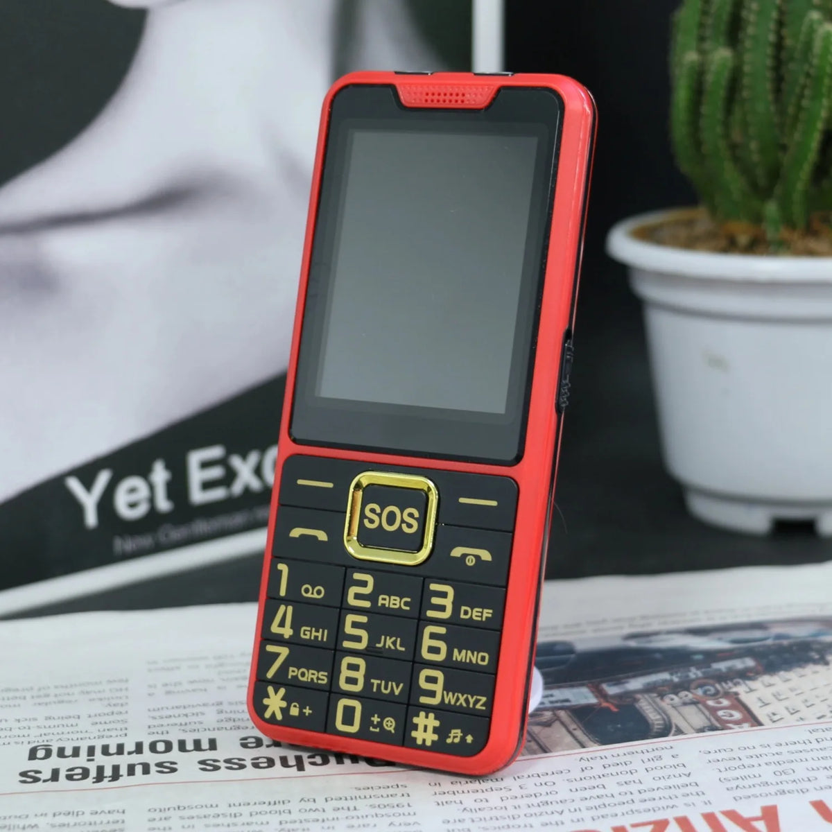 Red senior feature phone with SOS key and numeric keypad, front screen turned on