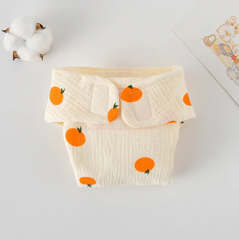 Reusable cloth baby diaper with orange fruit pattern on textured cream fabric, soft infant care essential.