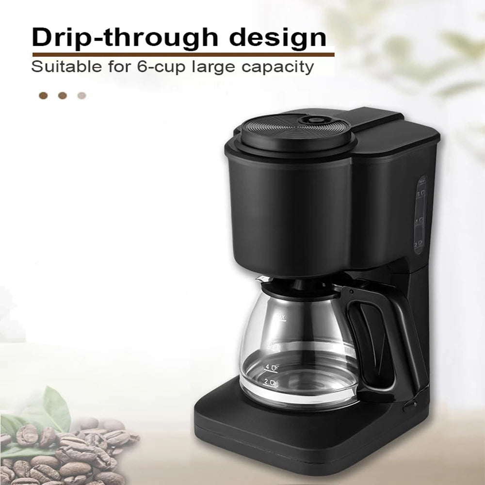 Black 6-cup drip coffee maker with glass carafe and plastic body on a white background with coffee beans.