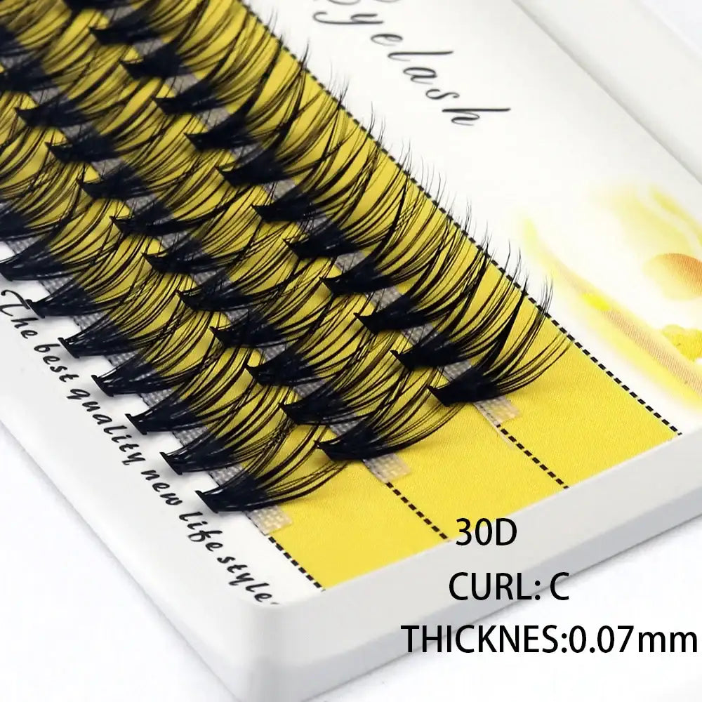 A tray of 30D black mink individual eyelash clusters with a C-curl and 0.07mm thickness on a yellow background.