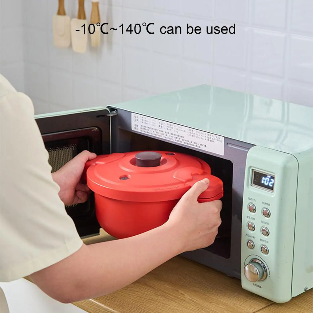 Red microwave pressure cooker pot with lid placed inside an oven, hands holding cooker.