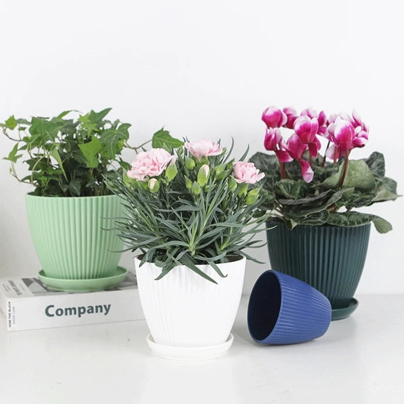 Ribbed plastic plant pots with tray in mint, white, and dark teal with flowers