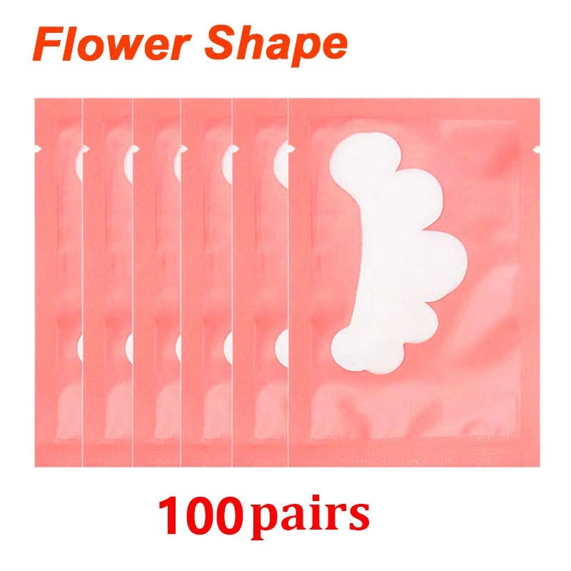 Flower-shaped white lint-free eye patches in pink individual gel sticker sachets for eyelash extension application.