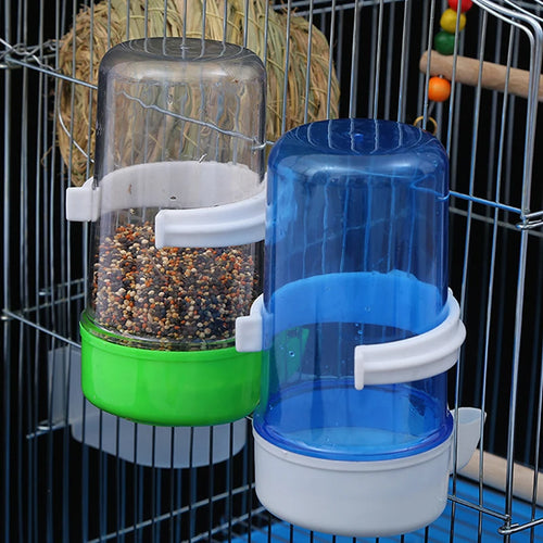 Plastic automatic bird feeder and water dispenser, green and blue bowls with clear reservoirs and white brackets.