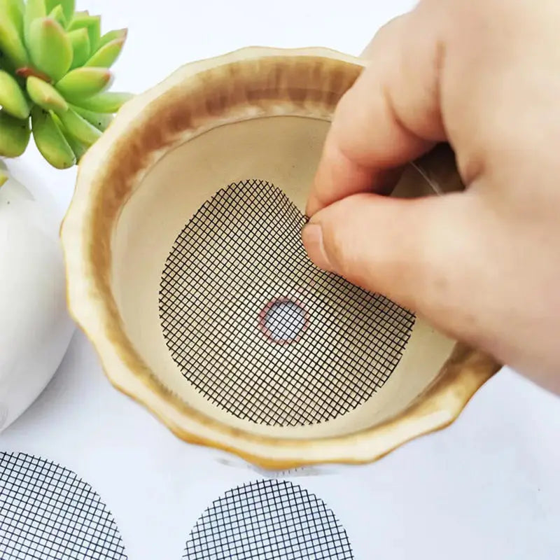 Round beige mesh drainage screen with grid and center hole for pot bottoms