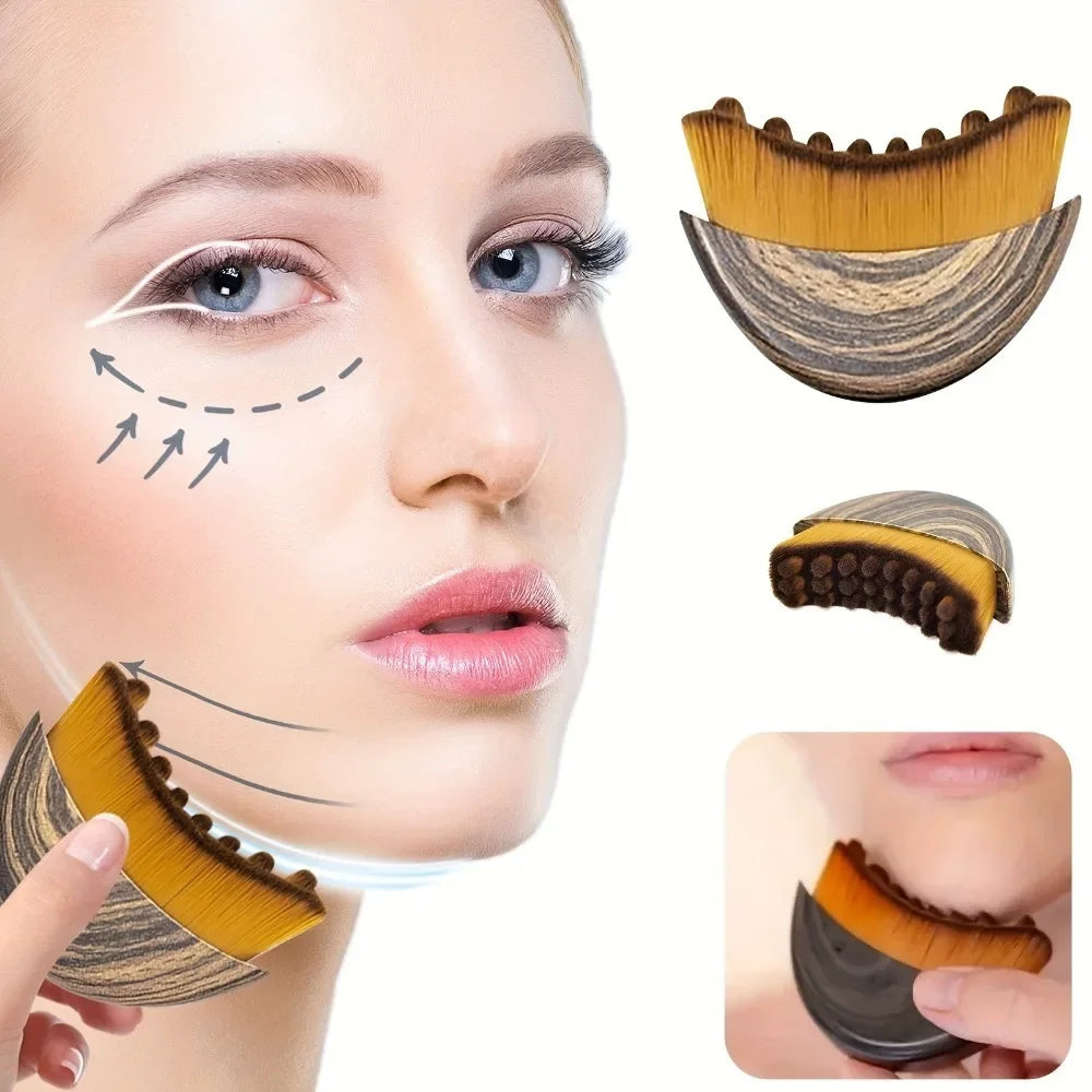 A contoured face brush with gold bristles and a wood-grain handle, shown in use for lymphatic drainage massage.