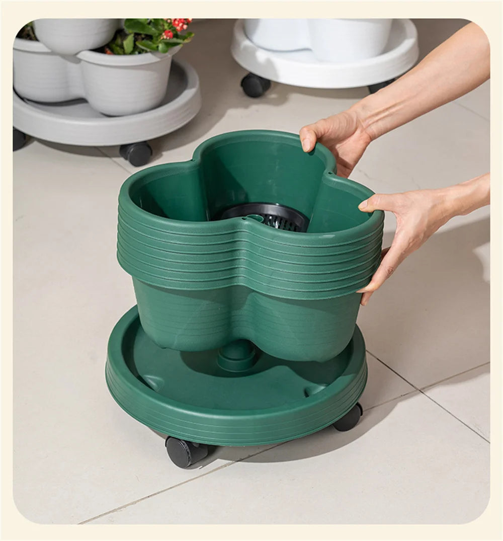 Stackable vertical garden planter on wheels with green pots, being lifted by a hand indoors.