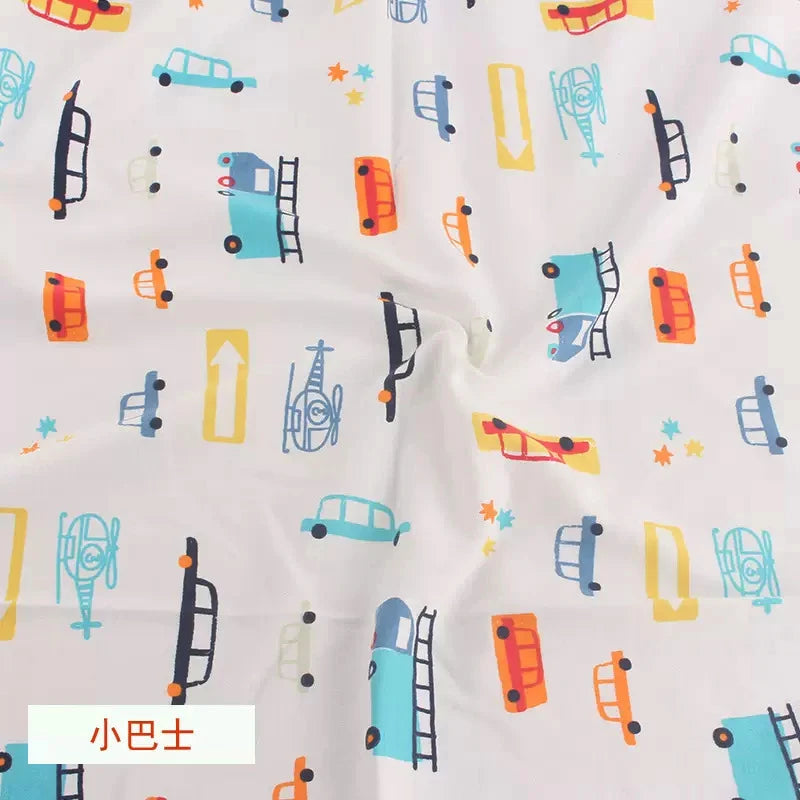 White organic knit jersey fabric with a colorful cartoon print of cars, trucks, helicopters, and arrows for children.