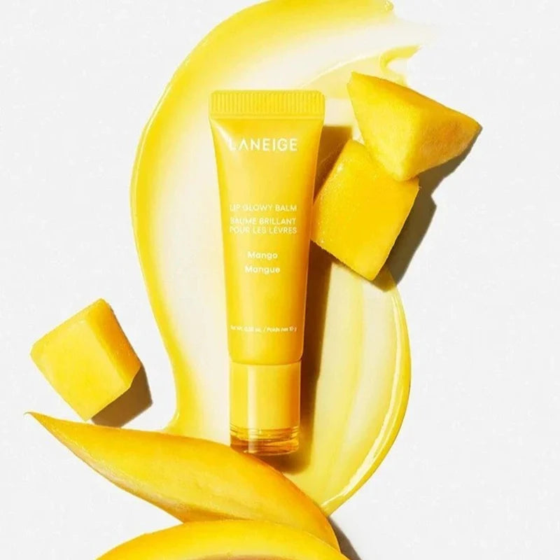 Laneige Mango Lip Glowy Balm tube with yellow hydrating texture swatch and fresh mango slices.