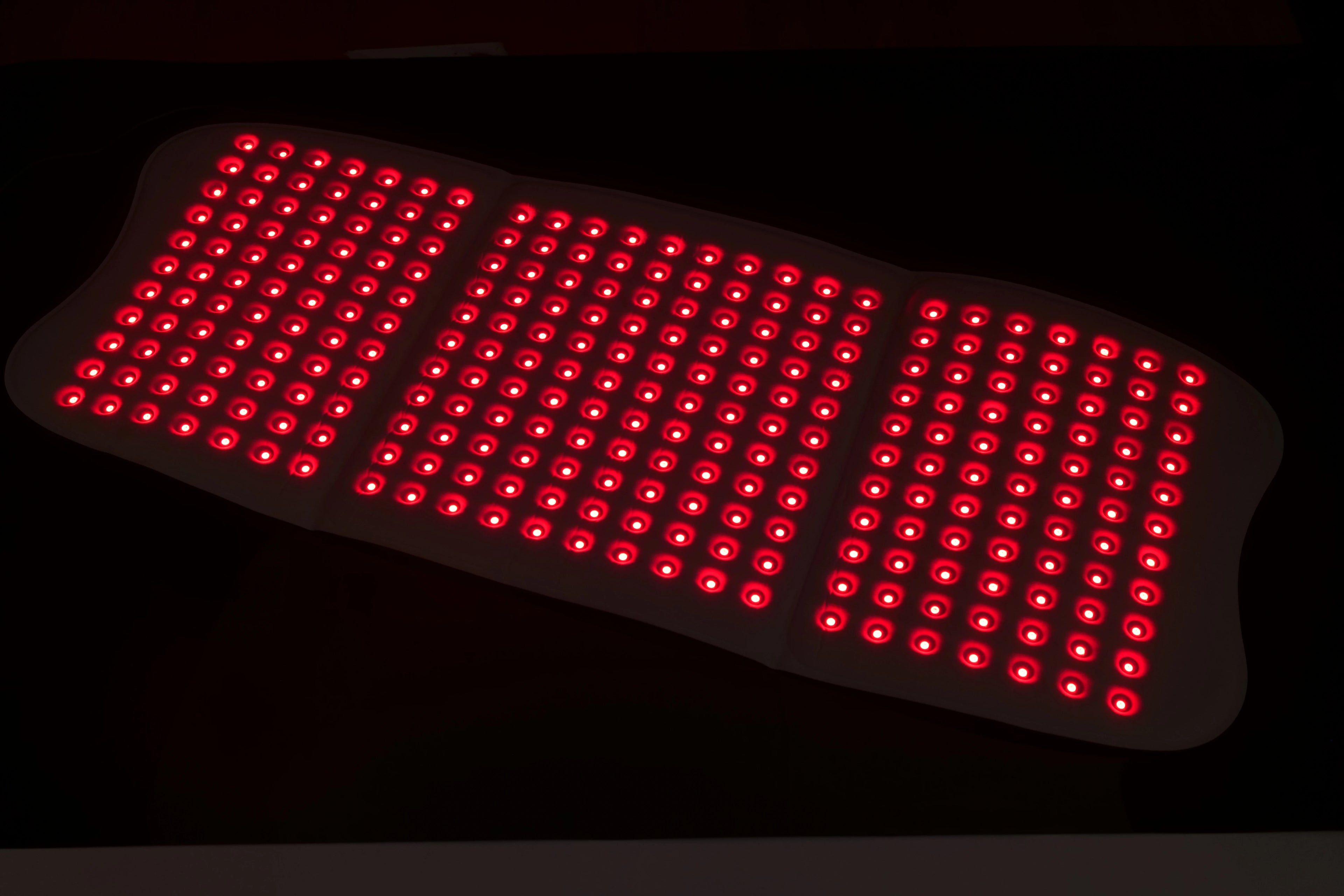 A large, rectangular red light therapy mat featuring a dense grid of 792 illuminated red LED lights.