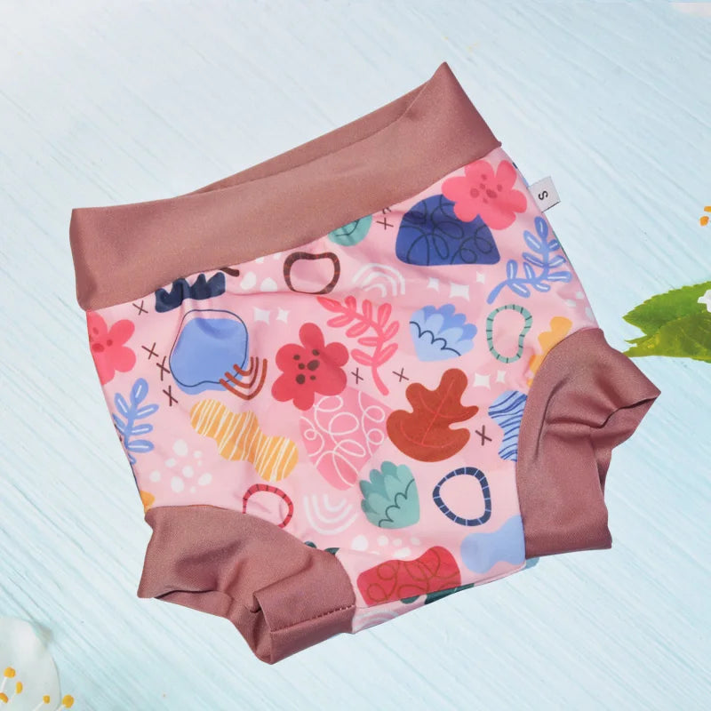 Small baby swim diaper in pink with colorful abstract floral print and brown trim, size S.