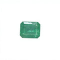 Octagonal emerald-cut green gemstone on white felt