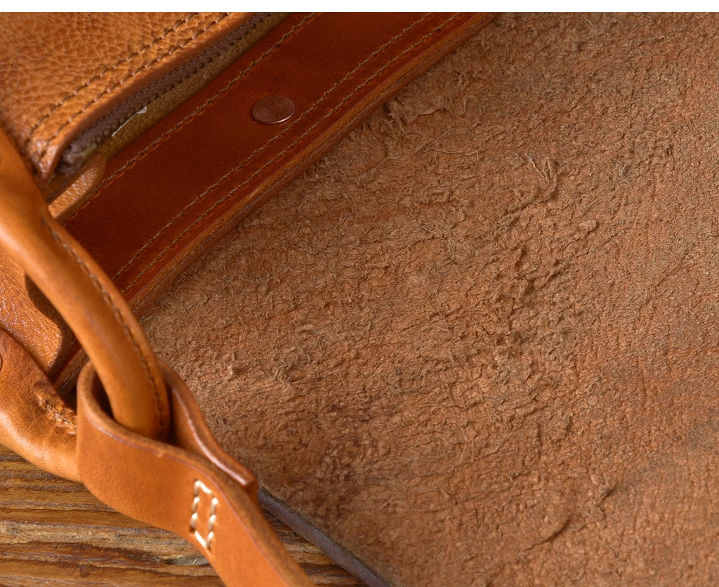Vintage tan genuine leather designer messenger bag with premium cowhide grain and reinforced stitched strap detail.
