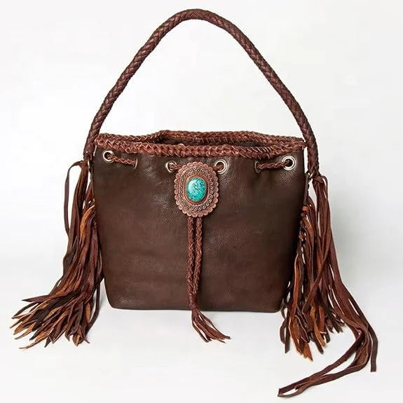 Vintage brown leather bucket bag with braided handle, long side fringe, and decorative turquoise stone center accent.