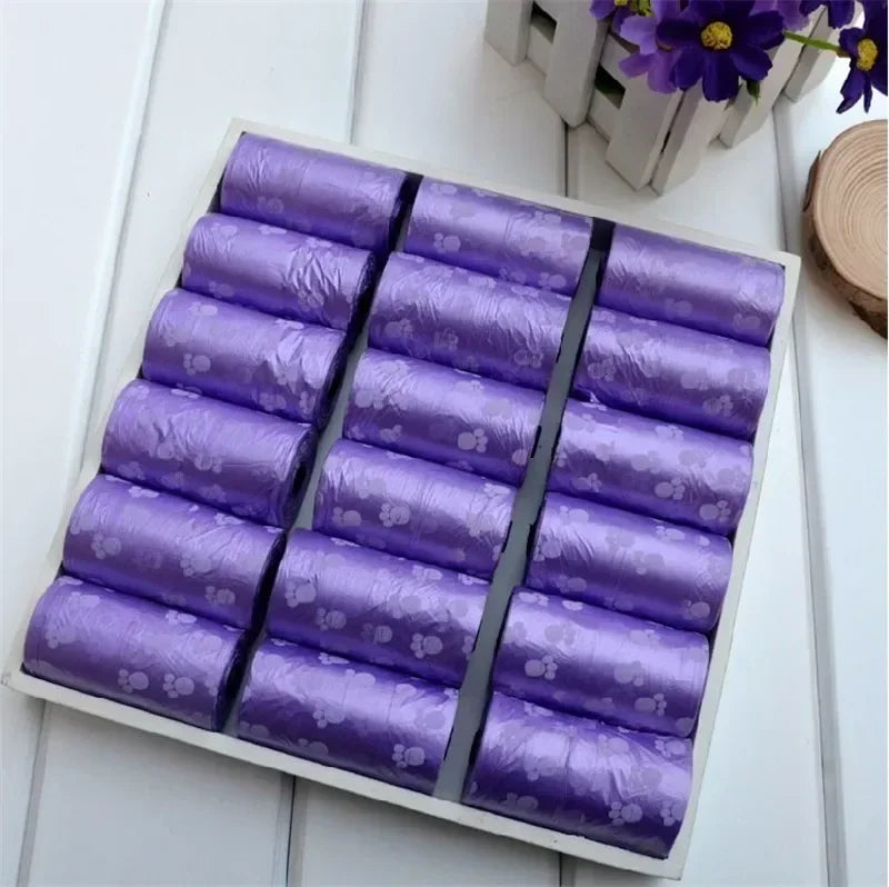 Purple leak-proof dog poop bags with cute cartoon paw prints for easy, clean pet waste disposal. Bulk pet supply rolls.