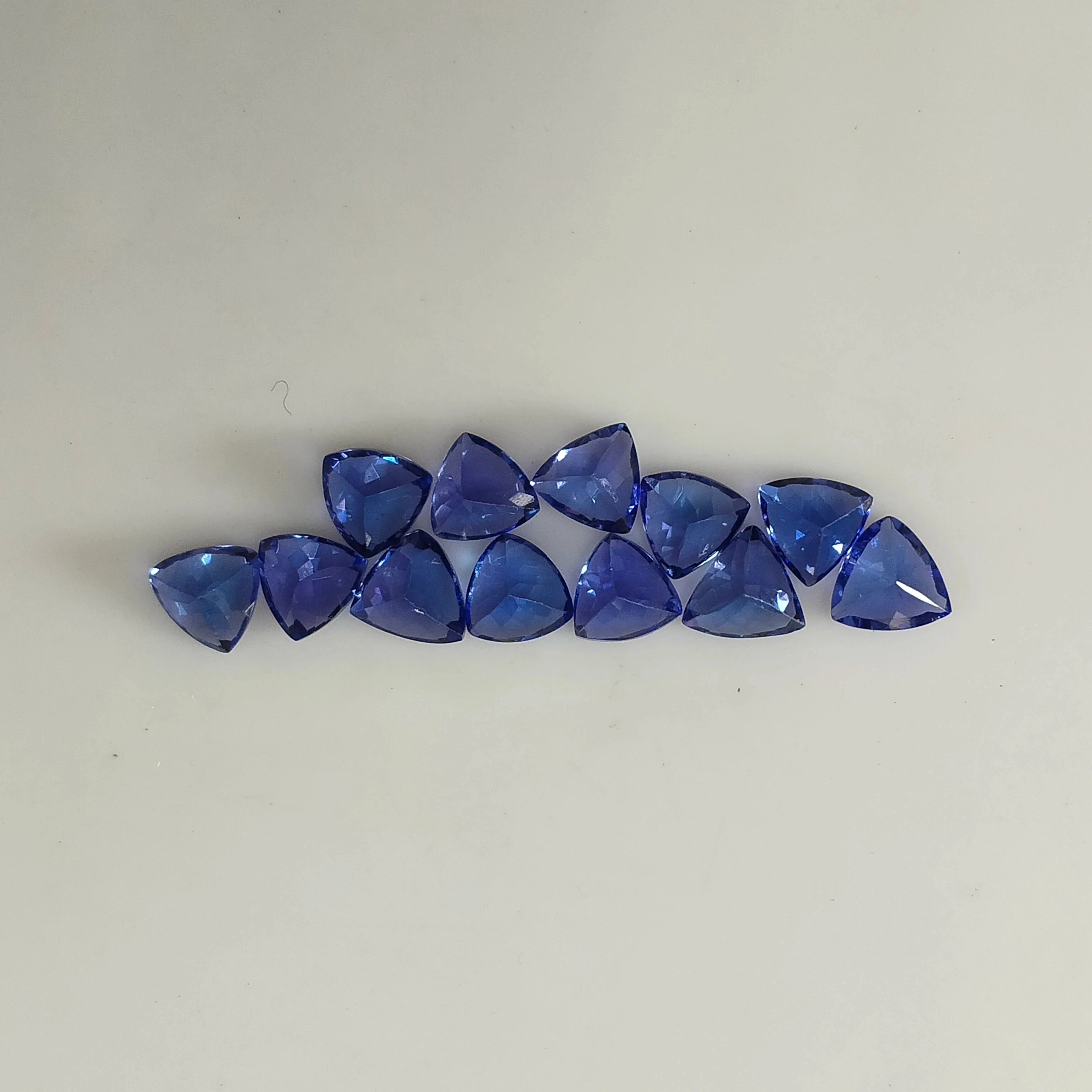 Loose blue trillion-cut gemstones lined up in a row