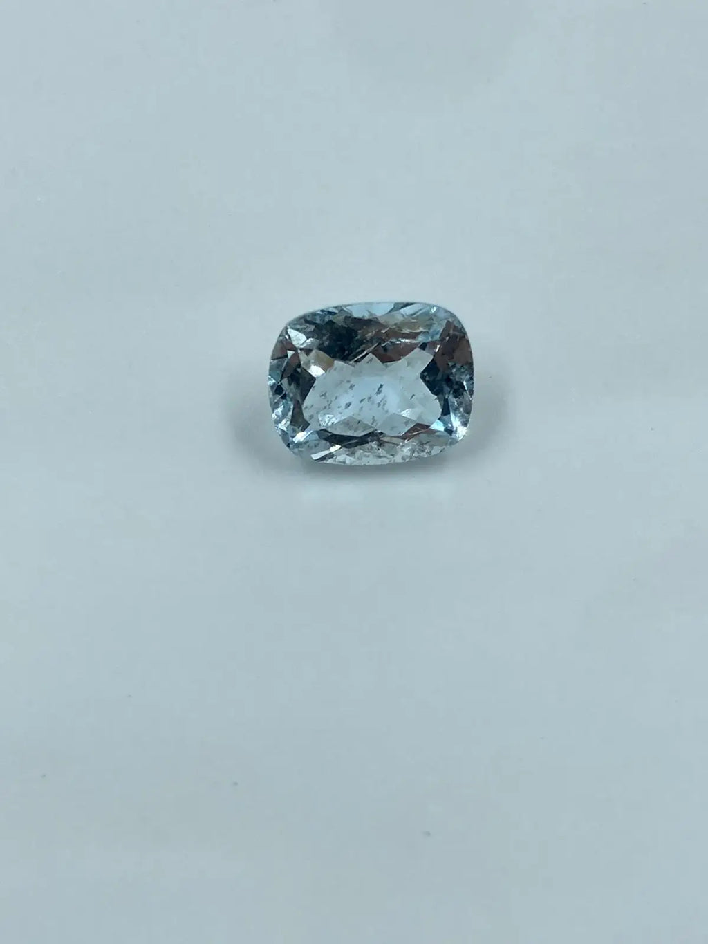 Sky-blue cushion-cut loose gemstone, clear faceting with rounded-oval shape