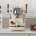 Hambach cream espresso machine with chrome accents, wooden levers, and digital display brewing coffee into a glass.