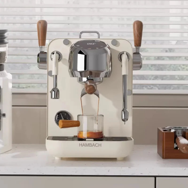 Hambach cream espresso machine with chrome accents, wooden levers, and digital display brewing coffee into a glass.