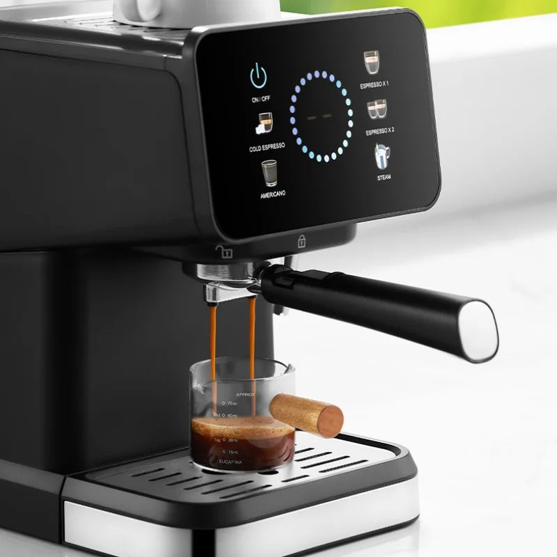 Bucafina black espresso machine with digital touch screen pouring coffee into a small glass measuring cup.