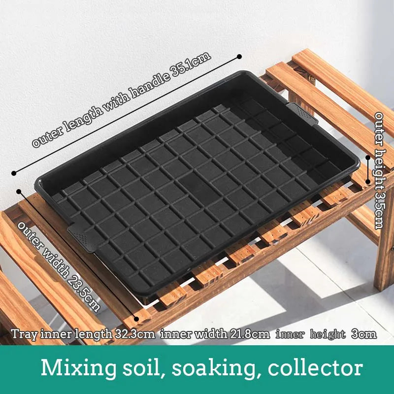 Black plastic drainage tray with grid pattern cells on a wooden support frame with handles.