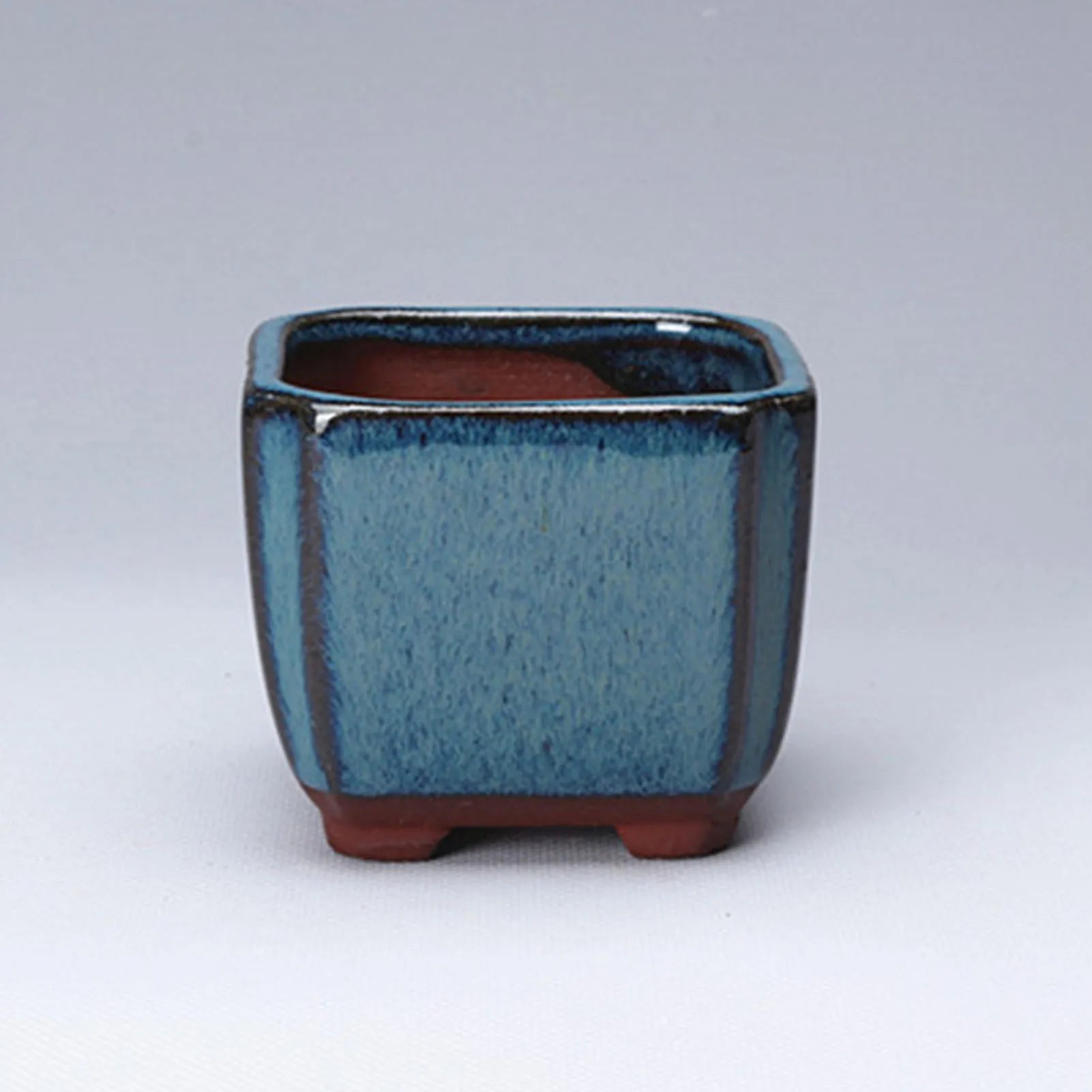 Blue glazed ceramic pot close-up with terracotta interior and open top