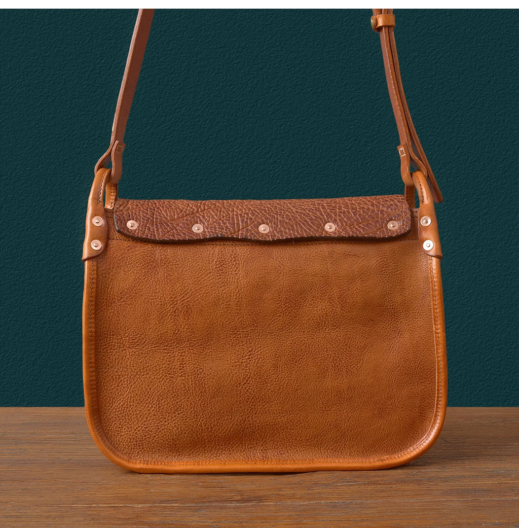 Vintage luxury genuine tan cowhide leather messenger bag with rivet details and adjustable shoulder strap.