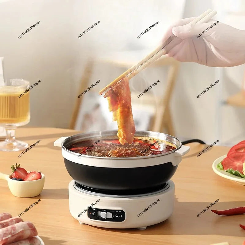 Electric hot pot cooker with black bowl holding broth, lid open while food is added