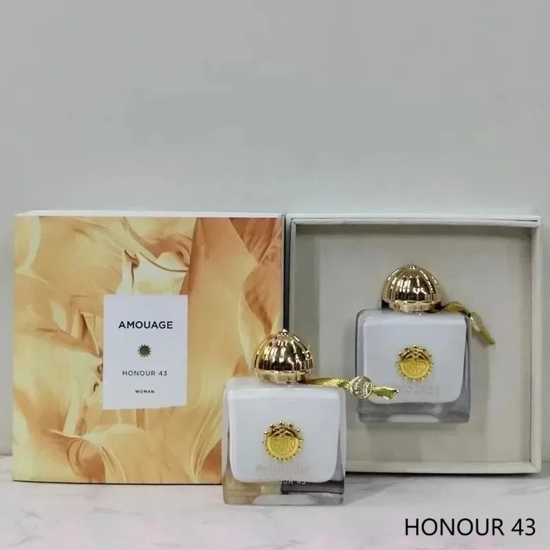 Amouage Honour 43 Woman perfume set with white square bottles, gold caps, and elegant gold gift box packaging.